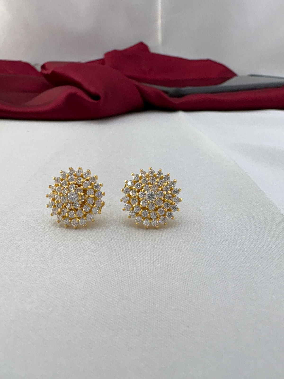 Classic Sparkle white AD stud earrings pair on fabric background featuring brilliant clear stones in gold – front view