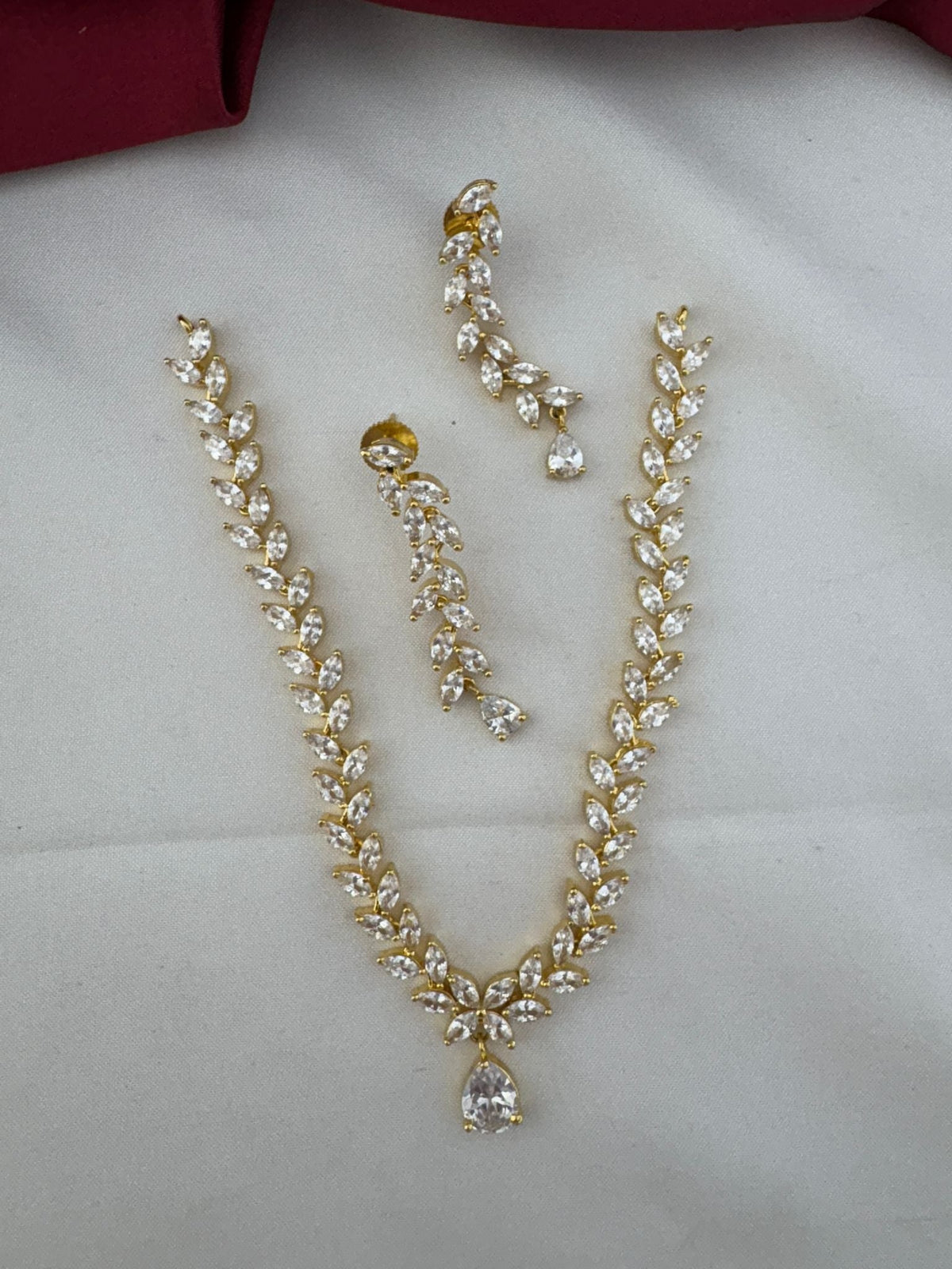 Festive Dazzle AD Stone Floral Short Necklace Set with matching earrings, top view on a white fabric background – view 3