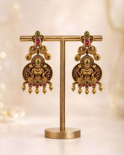 gold-plated ruby and emerald earrings on jewellery display – front view