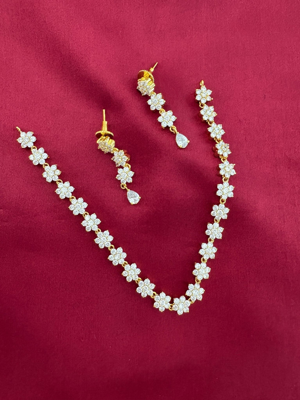 Solitaire Sparkle AD Stone Short Necklace Set, detailed view of floral links and earrings on maroon – view 3